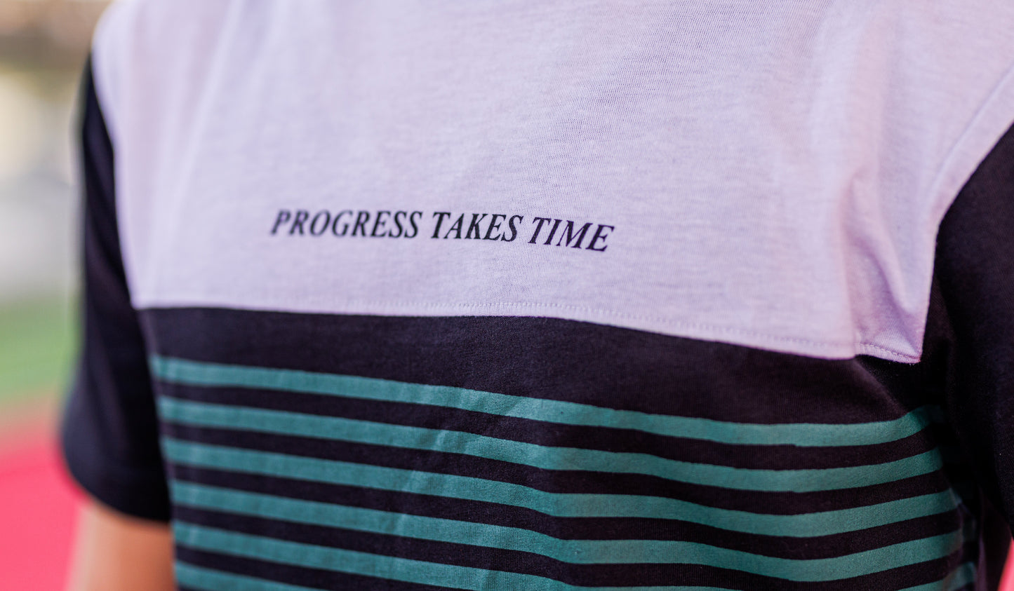 T-shirt with 'PROGRESS TAKES TIME' text on a striped design