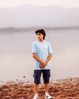 Person standing on a rocky shore with a misty background