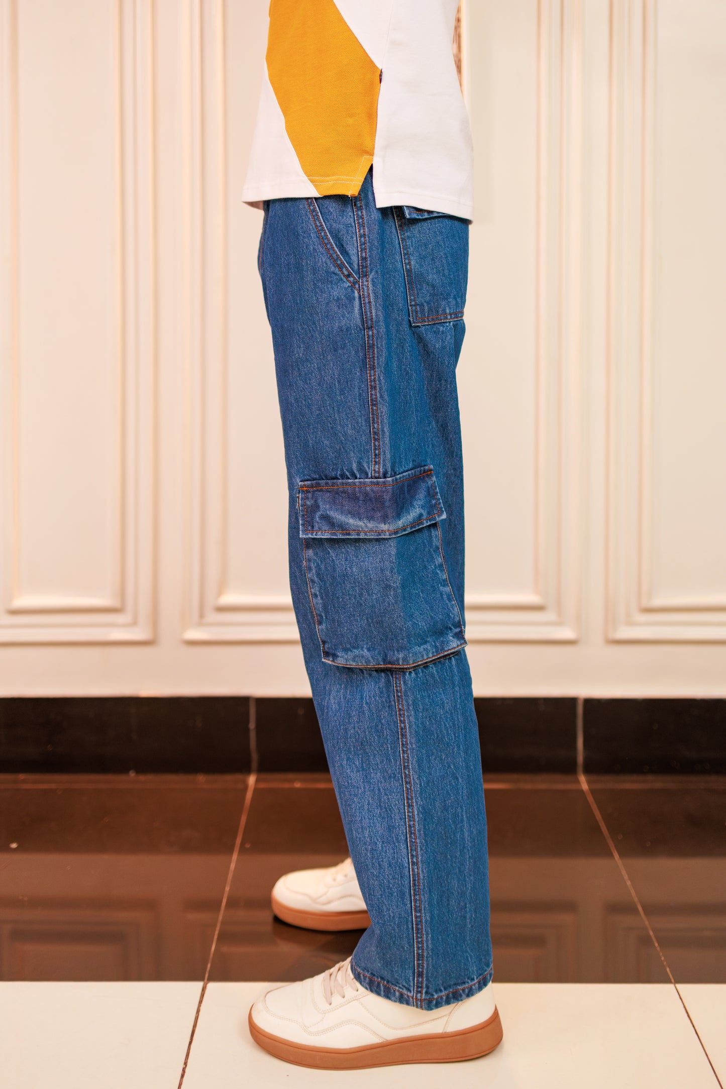 Blue cargo pants worn by a person on a white background