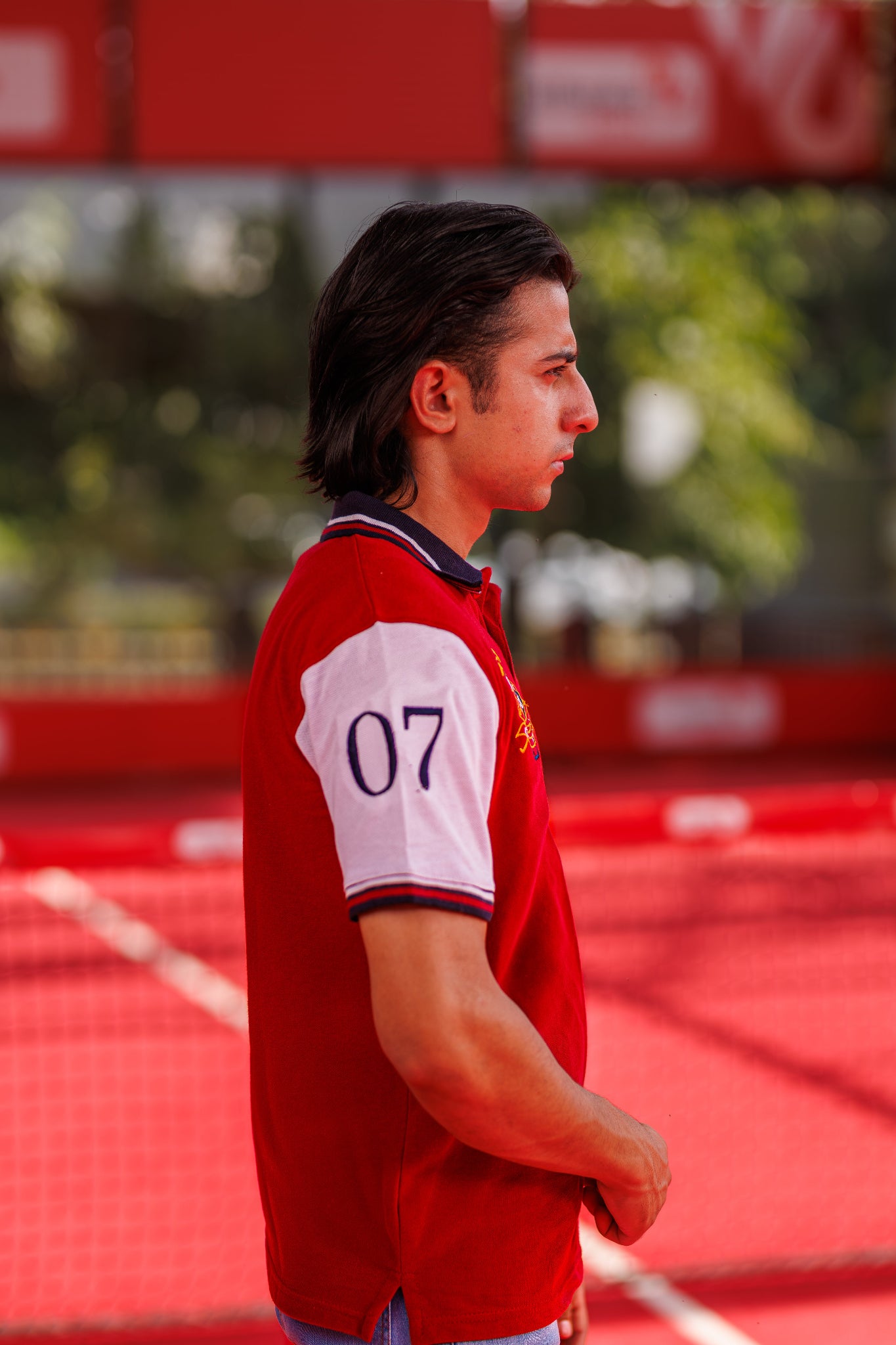 Person wearing a red sports jersey with the number 07 on a sports field.