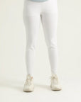 A pair of white leggings on a female model paired with a blue top and white sneakers.
