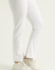 Person wearing white pants and light-colored shoes on a plain background