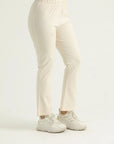 A pair of beige flared leggings with a high waistband, worn with white sneakers.