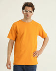 A male model wearing a yellow loose fit t-shirt with a rib-trimmed neckline, dropped shoulders, and a straight-cut hem.