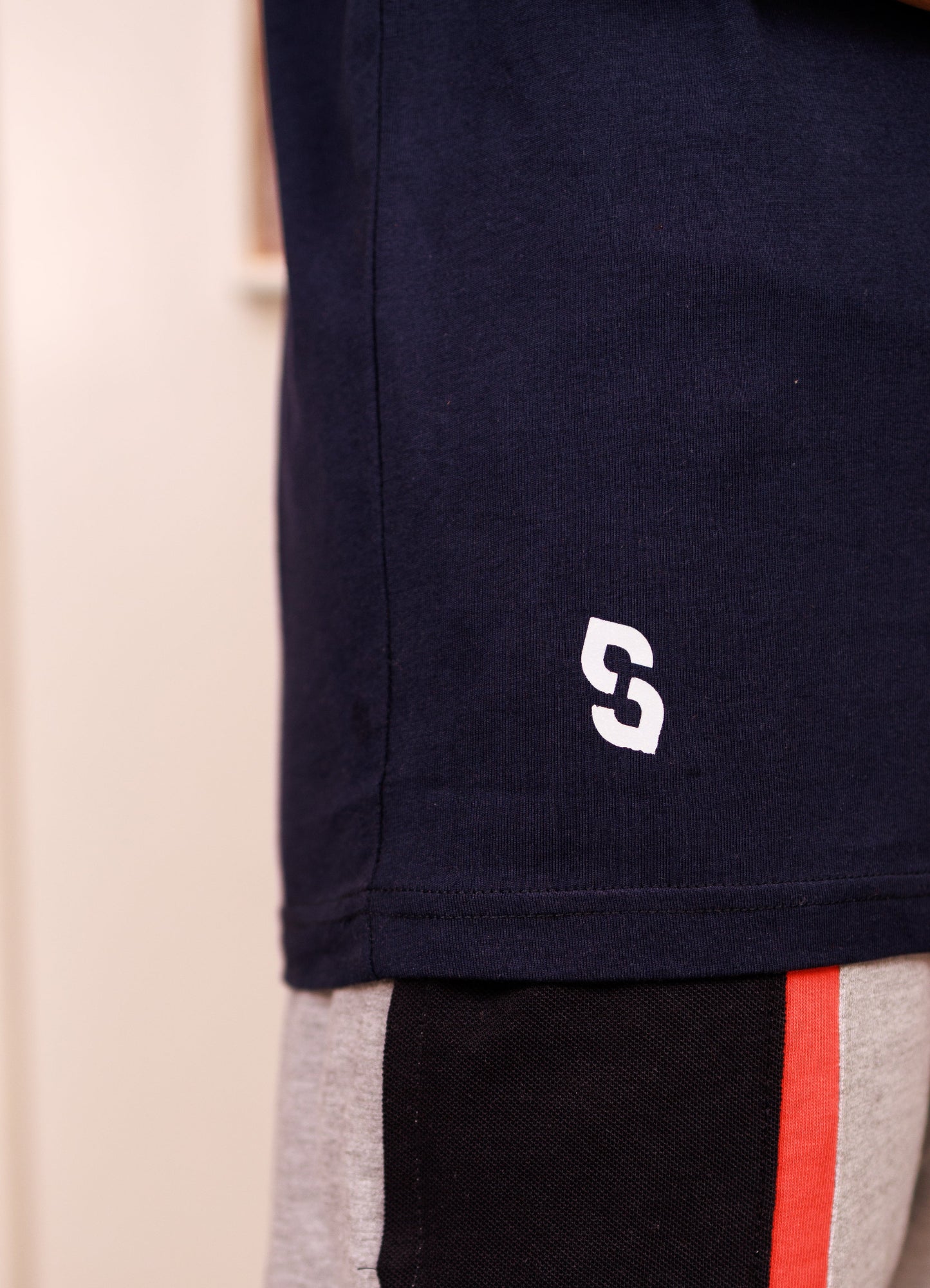 Navy shorts with a logo on the corner, beige and black pants with red stripe in the background