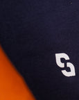 Close-up of a black shirt with a white logo on an orange background