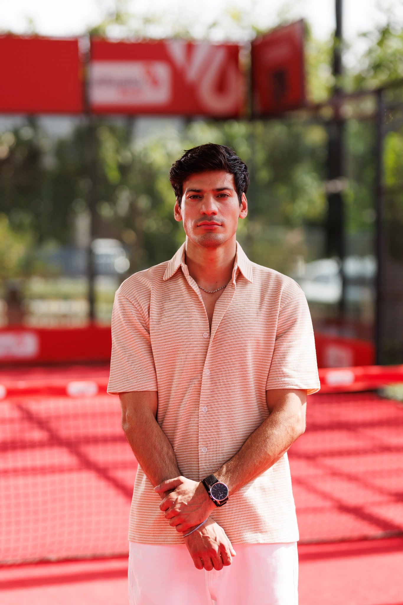 Man standing on a red sports court with a blurred background