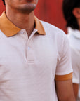 Two men wearing matching polo shirts with a blurred background