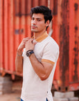 Man adjusting his collar in front of orange shipping containers