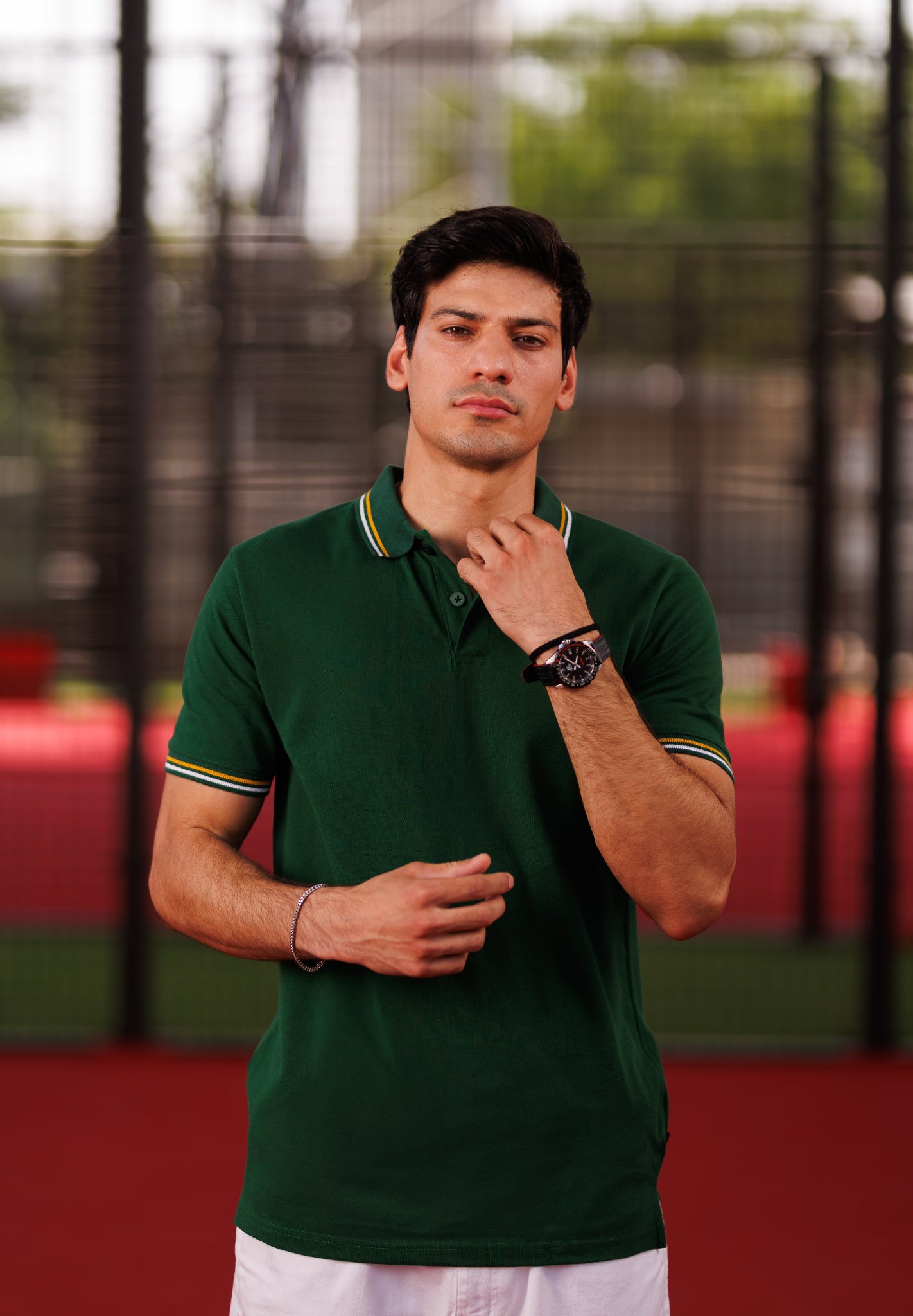 Man wearing a green polo shirt with a blurred background