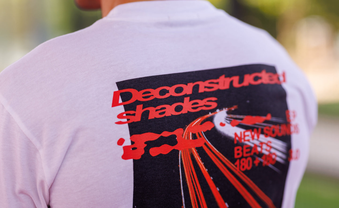 Back view of a person wearing a t-shirt with 'Deconstructed shades' design.