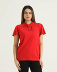 A woman wearing a red frill knit top with a round neckline, frill cap sleeves, and a drawstring detail at the front.