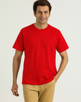 Man wearing a red t-shirt and beige pants on a white background
