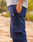 Navy cargo shorts with a brand logo worn by a person outdoors.