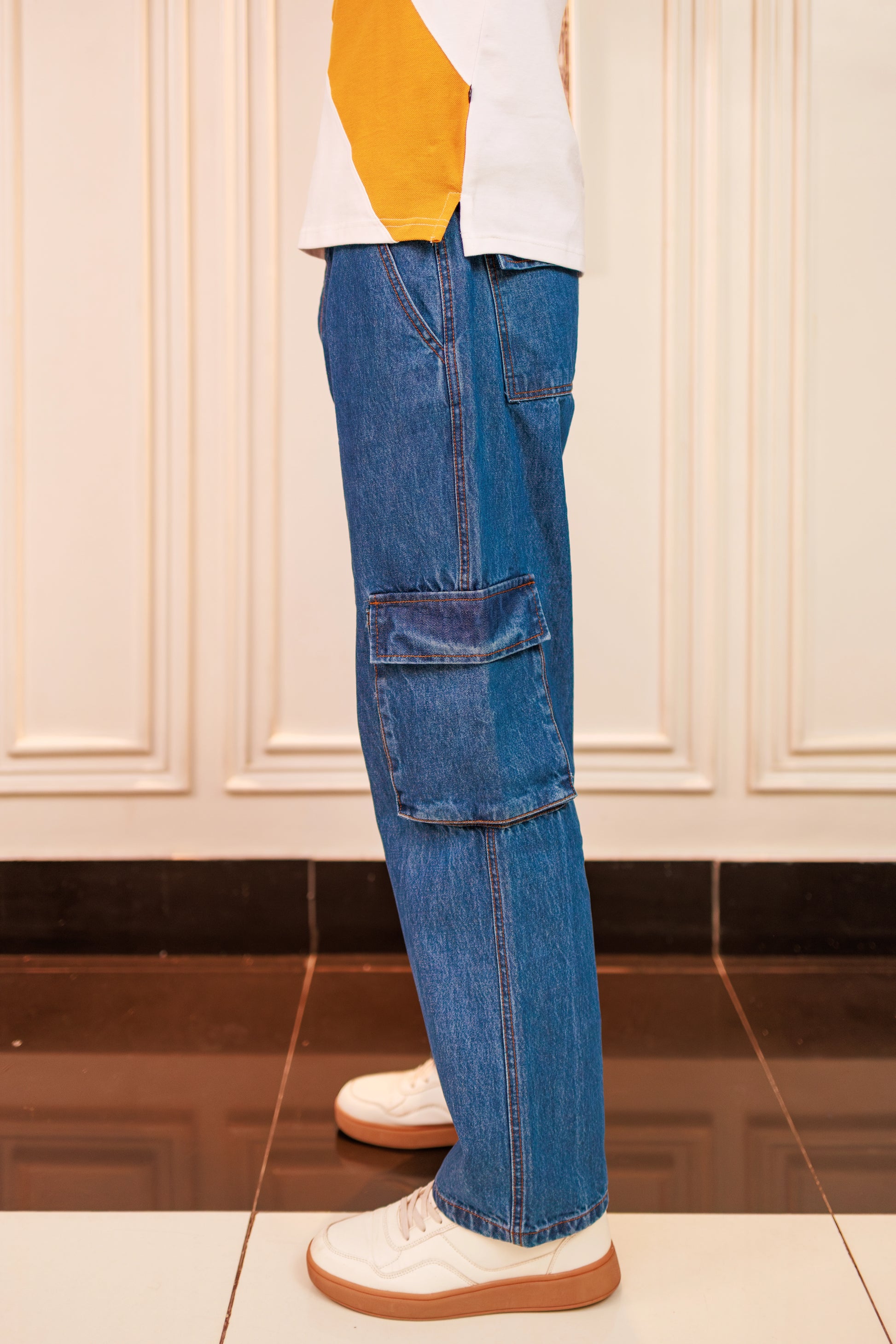 Blue cargo pants worn by a person on a white background