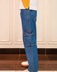 Blue cargo pants worn by a person on a white background