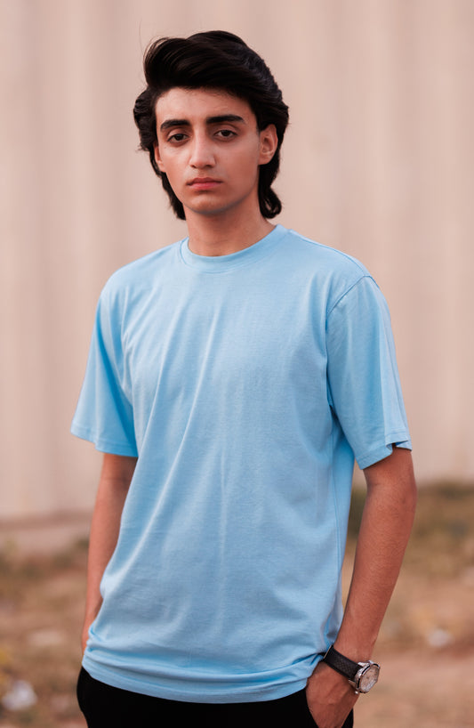 Person wearing a light blue t-shirt against a neutral background