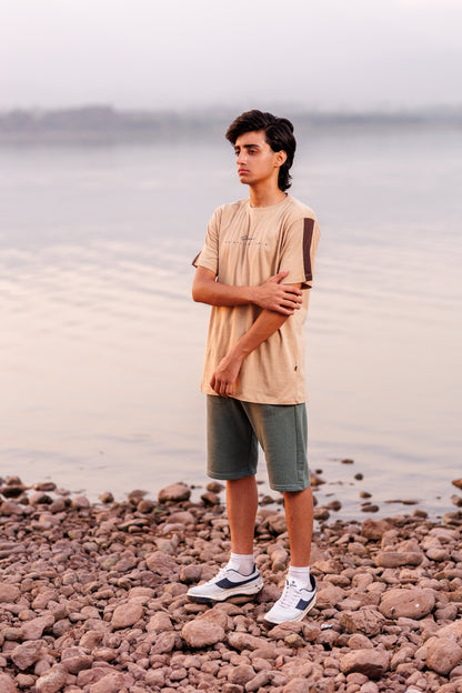 Person standing on a rocky beach with water in the background