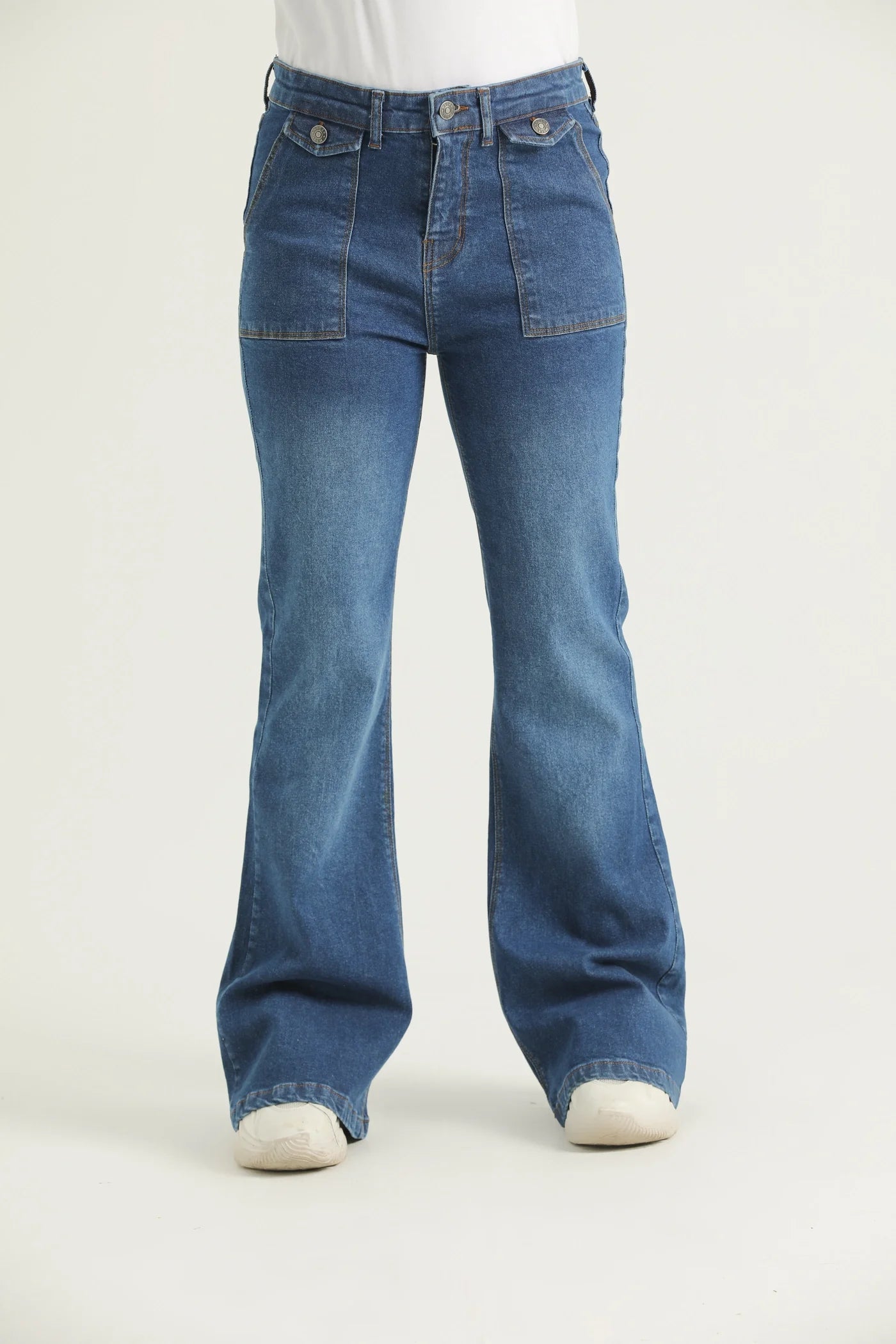 A pair of medium blue bootcut denim jeans with scope pockets, fly with zipper and metallic button.