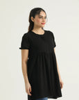 A model wearing a mid-length dark saddle top with short sleeves and a round neckline, made of georgette weave fabric.