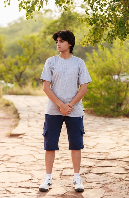 Person standing on a stone path with greenery in the background