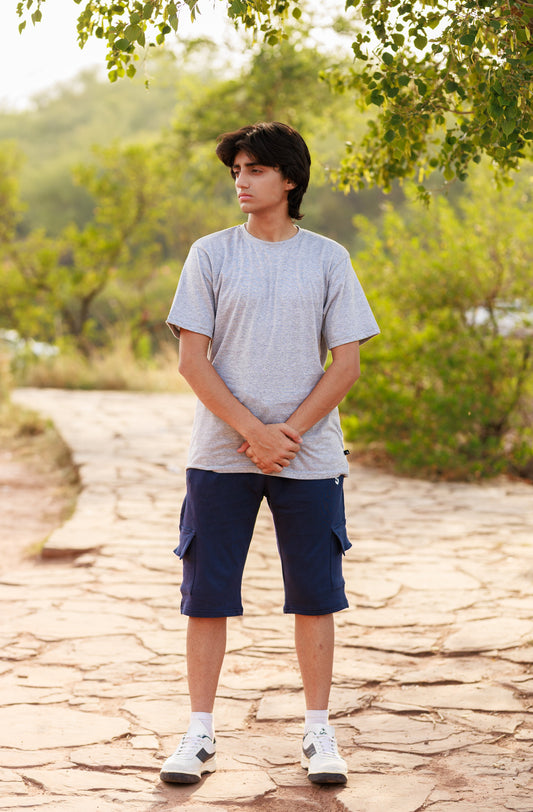 Person standing on a stone path with greenery in the background