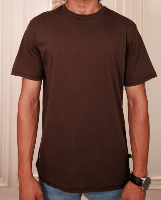 Person wearing a plain brown t-shirt with a neutral background