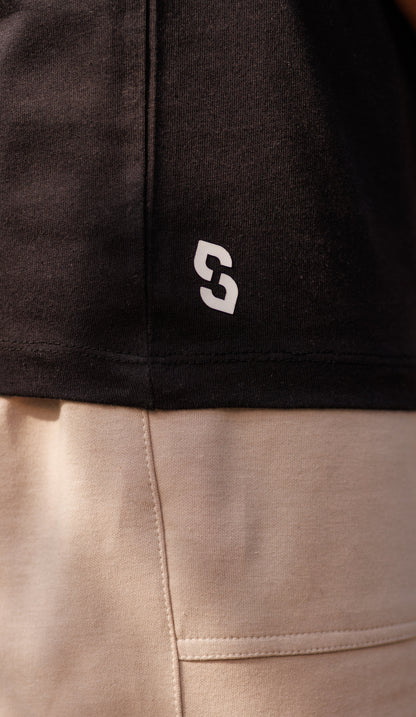 Close-up of a black and beige garment with a logo on the black section.