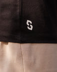 Close-up of a black and beige garment with a logo on the black section.