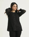 A model wearing a long-sleeved black lace top with full lace coverage and a round neckline with lace edging.