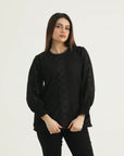 A model wearing a long-sleeved black lace top with full lace coverage and a round neckline with lace edging.
