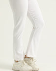 Person wearing white pants and light-colored shoes on a plain background