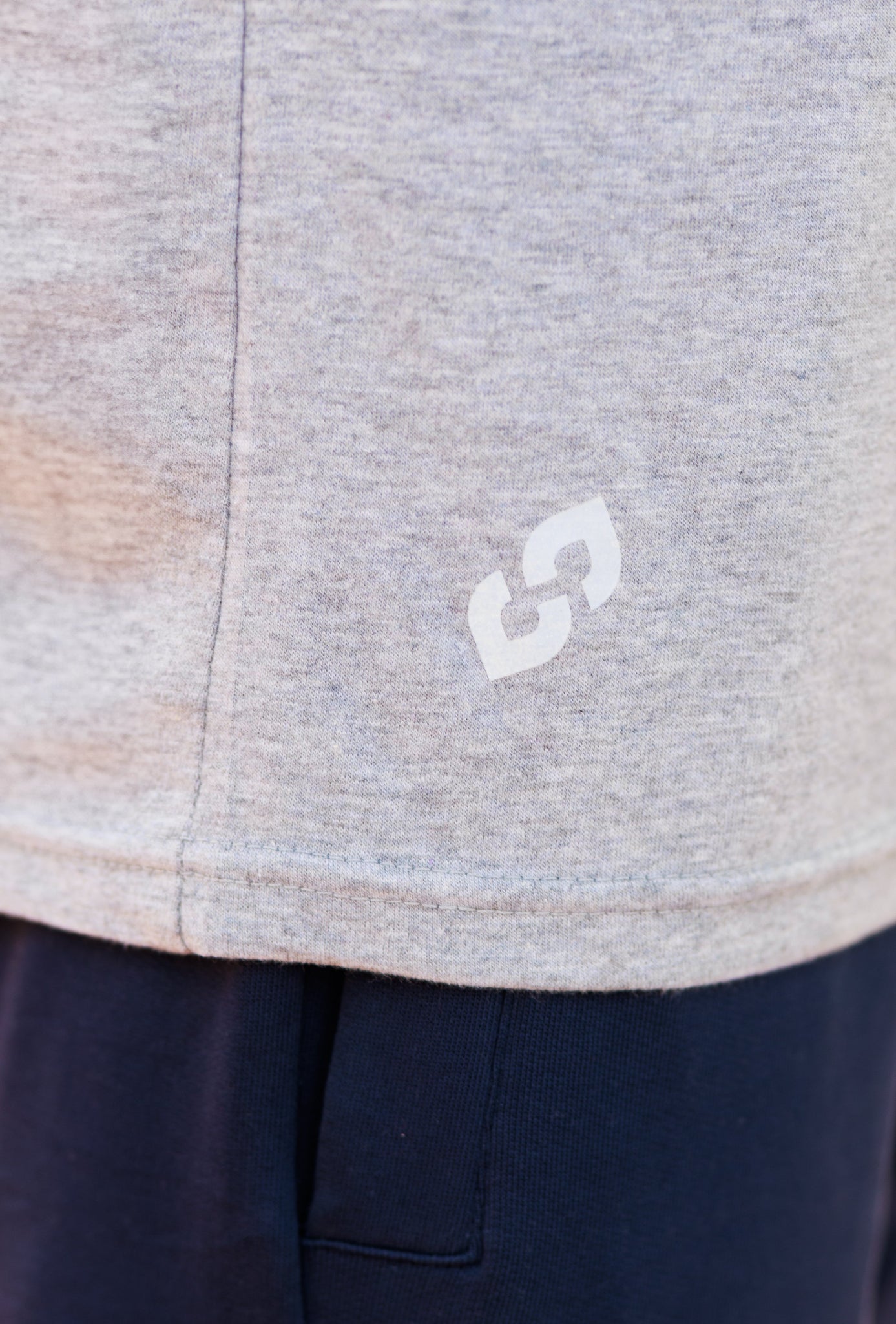 Close-up of a gray garment with a white logo on a navy background