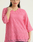 A model wearing a vibrant pink, scalloped V-neck, three-quarter straight sleeves, and a relaxed fit jacquard net top.