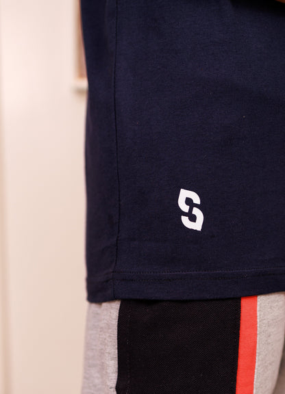 Navy shorts with a logo on the corner, beige and black pants with red stripe in the background