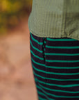 Close-up of green and black striped fabric with a blurred natural background