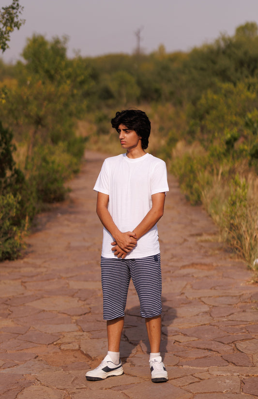 Person standing on a stone path in a natural setting with greenery.