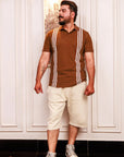 Man wearing a brown polo shirt with white stripes and beige shorts indoors.