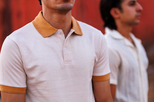 Two men wearing matching polo shirts with a blurred background
