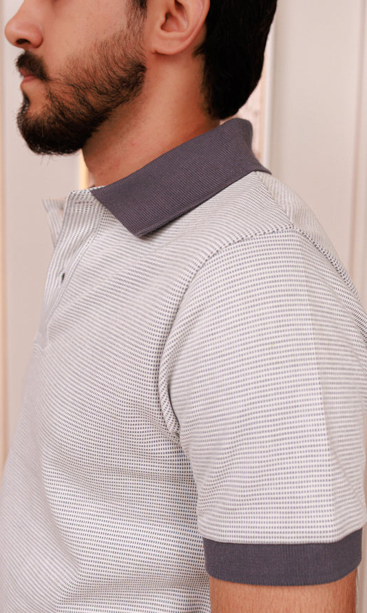 Man wearing a gray and white striped polo shirt with a collar.