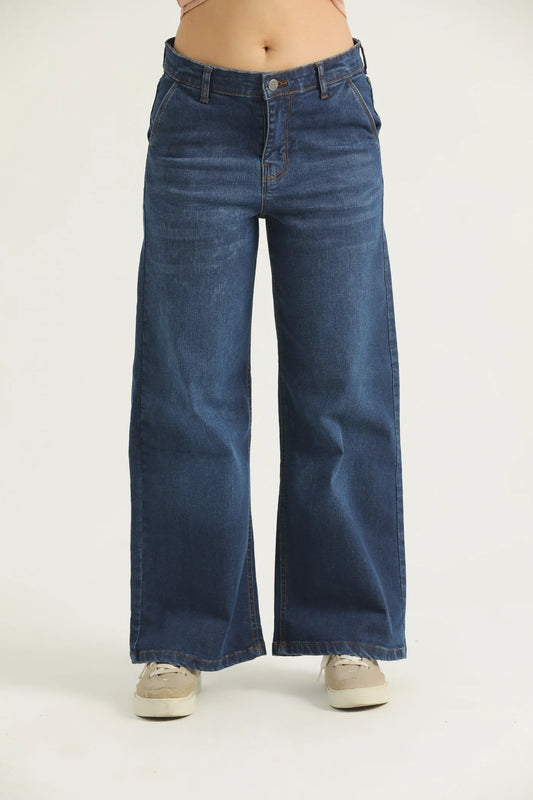 A pair of blue flared denim jeans with cross pockets, fly with zipper, and metallic button.
