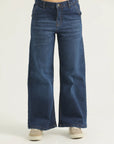 A pair of blue flared denim jeans with cross pockets, fly with zipper, and metallic button.