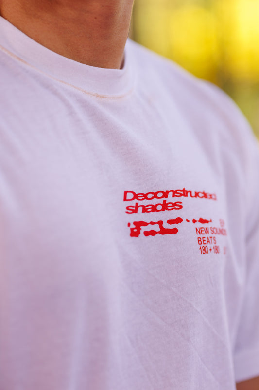 White t-shirt with red text and graphics on a blurred yellow background